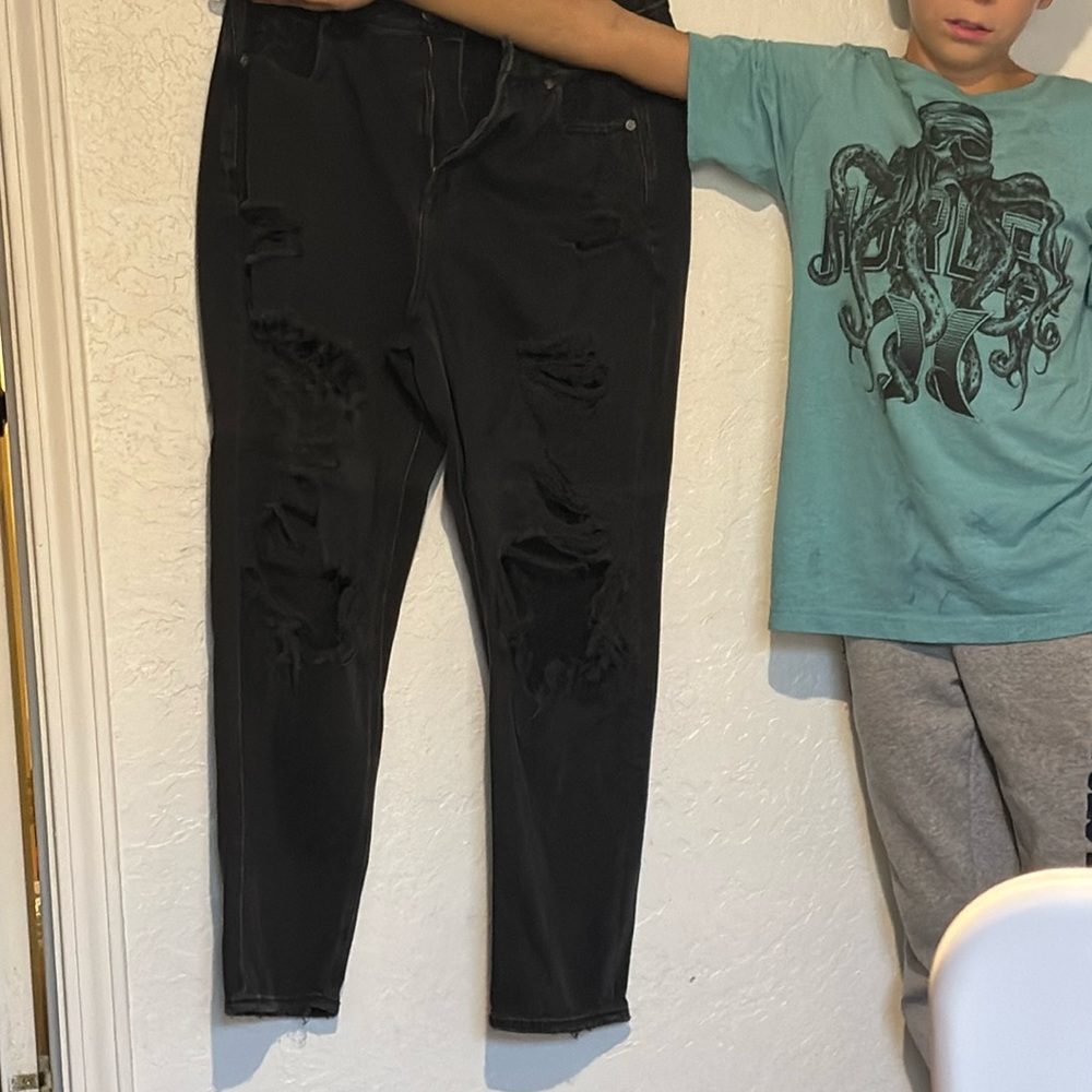 American Eagle. Black jeans with holes. One hole on back thigh. Size 12.